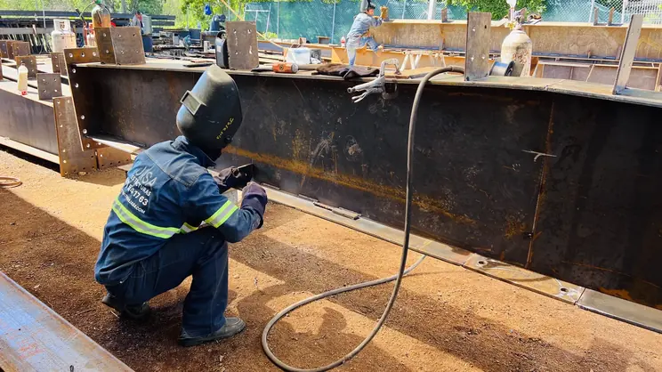 Soldador trabajando dentro de la trabe armada