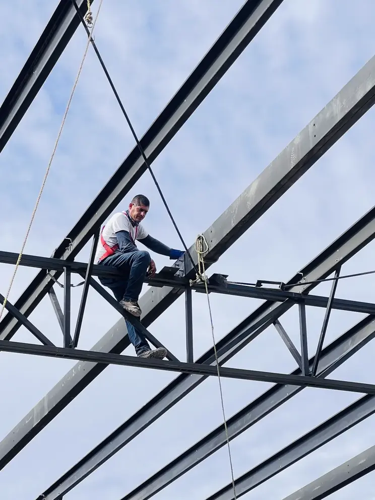 Trabajador caminando sobre la armadura en altura