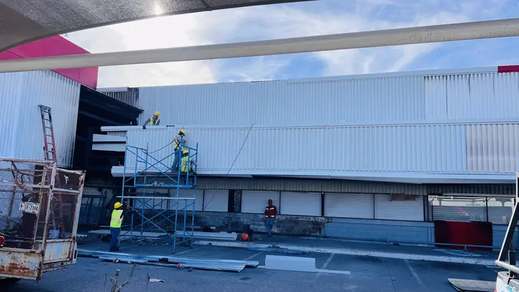 Tienda en reparación con andamios y cuadrilla tras el siniestro