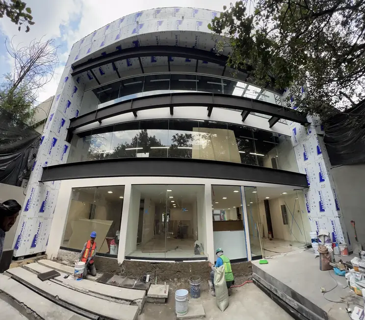 Fachada curva en obra con cuadrilla
